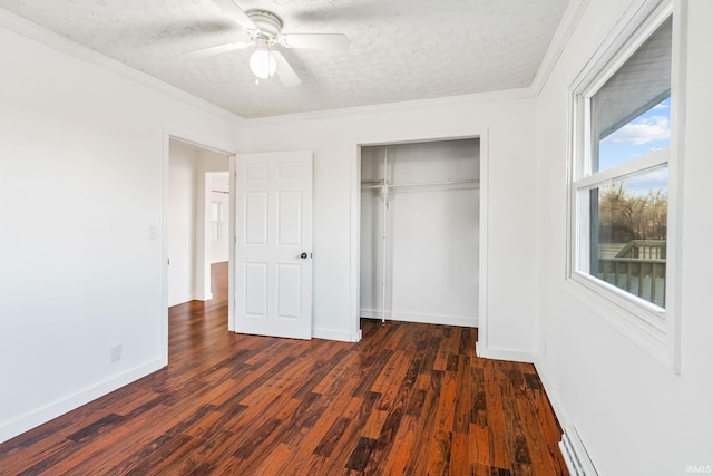 unfurnished bedroom featuring a closet, a textured ceiling, ornamental molding, and dark wood-style flooring