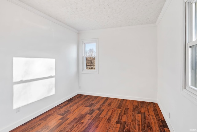 spare room featuring ornamental molding, a textured ceiling, baseboards, and dark wood-style flooring