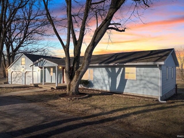 view of front of property with a garage, a porch, and driveway