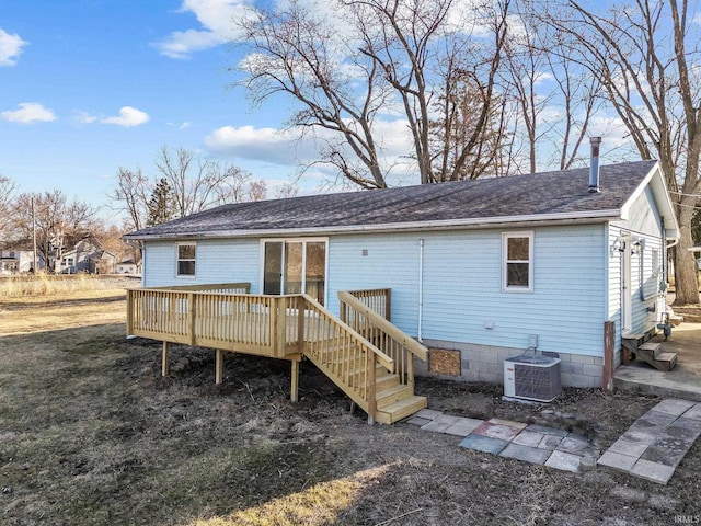 rear view of property featuring a wooden deck, roof with shingles, and central AC unit