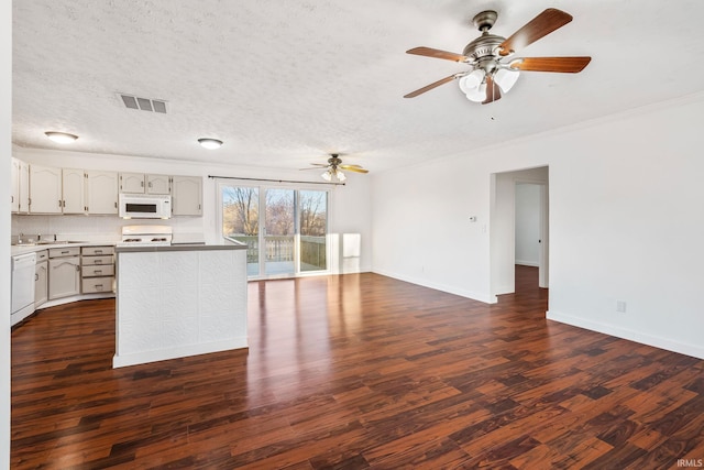 kitchen featuring visible vents, a ceiling fan, a textured ceiling, dark wood-style floors, and white appliances