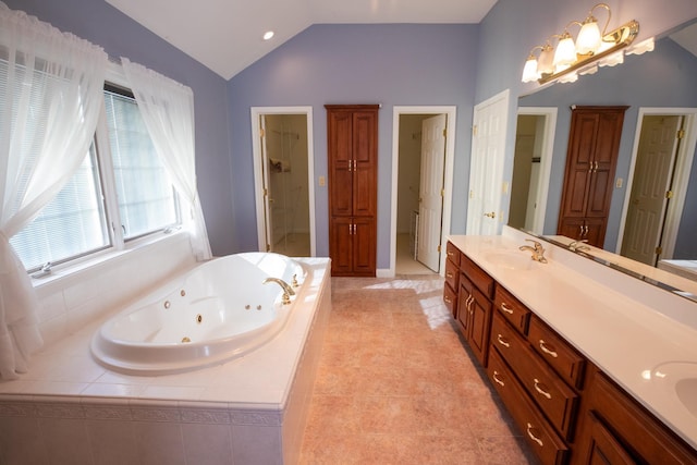 full bath with a jetted tub, lofted ceiling, double vanity, a closet, and a sink