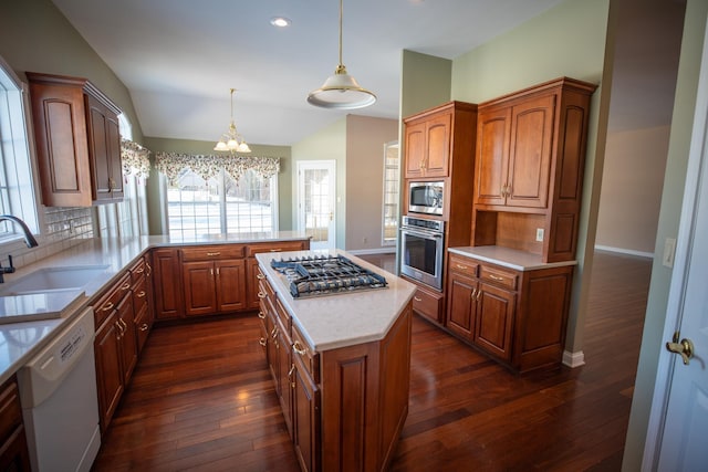 kitchen with dark wood-type flooring, lofted ceiling, a wealth of natural light, appliances with stainless steel finishes, and a sink