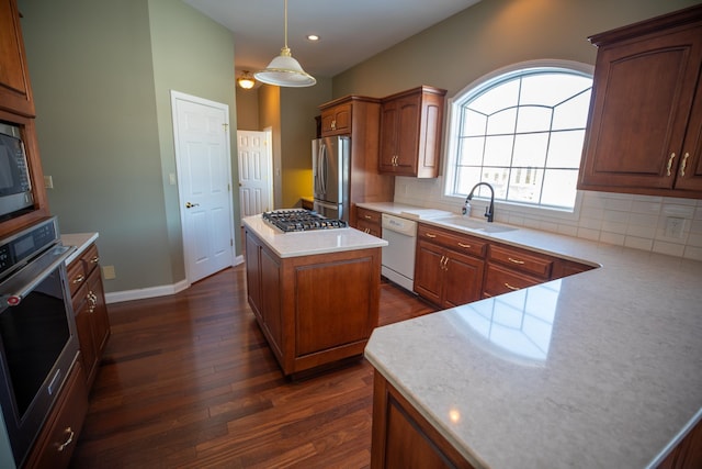 kitchen with a sink, stainless steel appliances, backsplash, and dark wood-style flooring