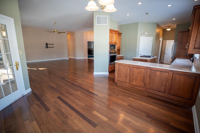 kitchen featuring visible vents, open floor plan, light countertops, appliances with stainless steel finishes, and dark wood-style floors