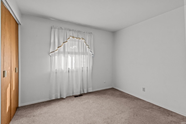 unfurnished bedroom featuring a closet, visible vents, and carpet floors