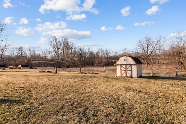 view of yard featuring a rural view, an outbuilding, a storage unit, and fence