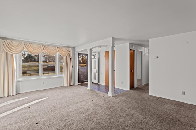 interior space with arched walkways, carpet, and decorative columns