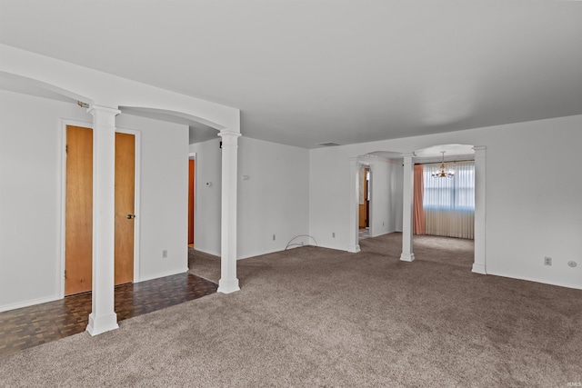 spare room featuring arched walkways, an inviting chandelier, ornate columns, and carpet floors