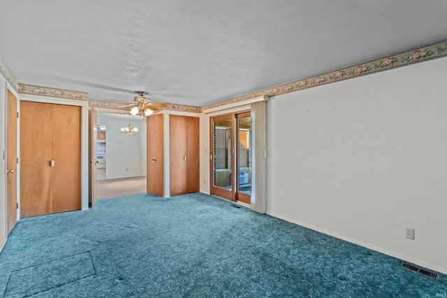 spare room with visible vents, carpet flooring, and an inviting chandelier