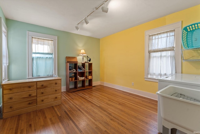 interior space with hardwood / wood-style floors, baseboards, and a sink