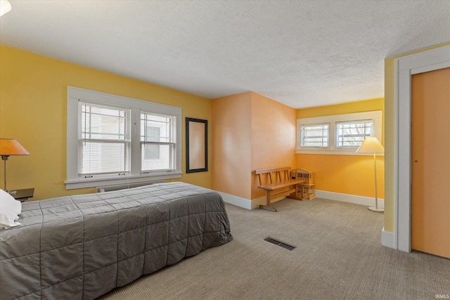 bedroom with visible vents, baseboards, carpet, and a textured ceiling