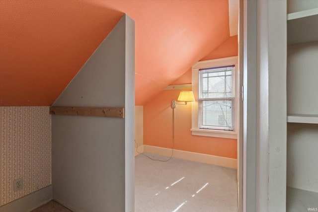 bonus room featuring wallpapered walls, lofted ceiling, carpet flooring, and baseboards