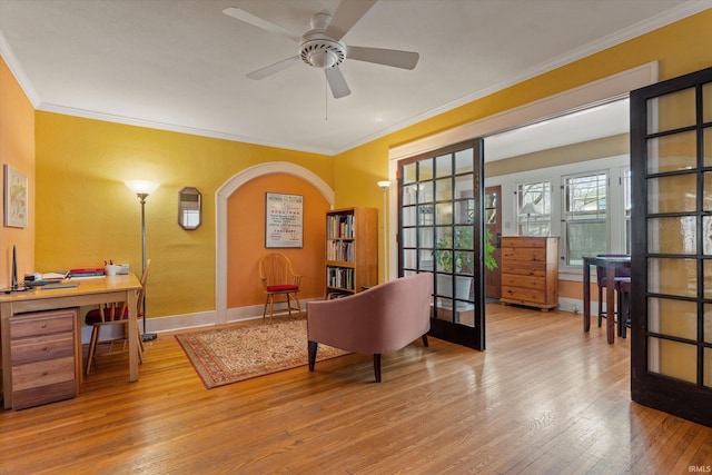 office space featuring hardwood / wood-style floors, a ceiling fan, baseboards, ornamental molding, and french doors