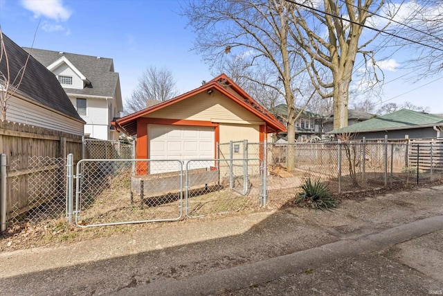 detached garage with a gate and fence