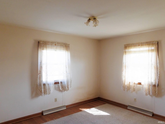 unfurnished room featuring visible vents, plenty of natural light, and wood finished floors