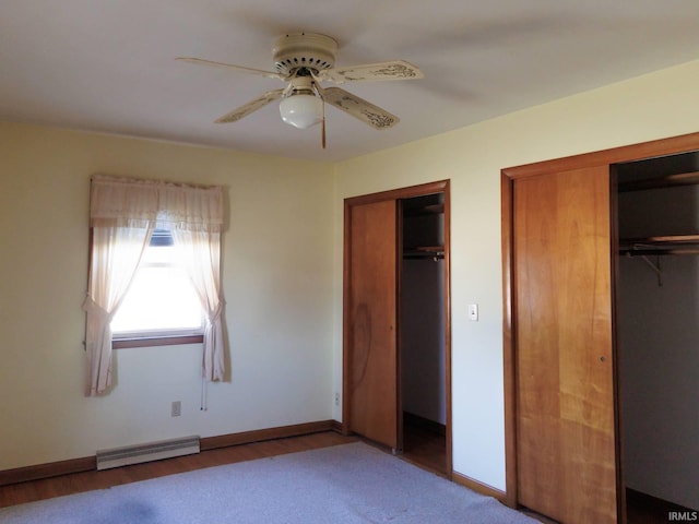 unfurnished bedroom featuring a ceiling fan, baseboards, two closets, and a baseboard radiator