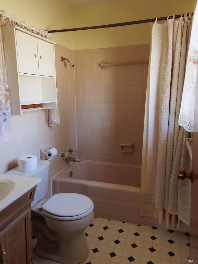 full bath featuring tile walls, vanity, toilet, and shower / tub combo