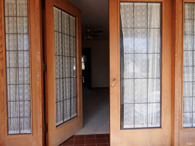 entryway featuring tile patterned floors, carpet, and ceiling fan