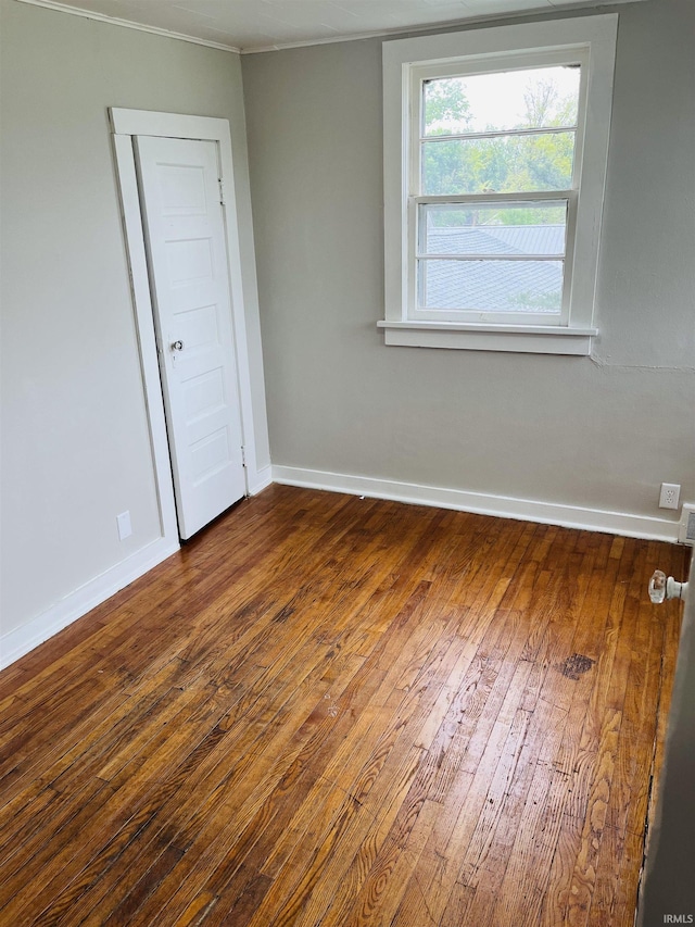 unfurnished room with hardwood / wood-style floors and baseboards