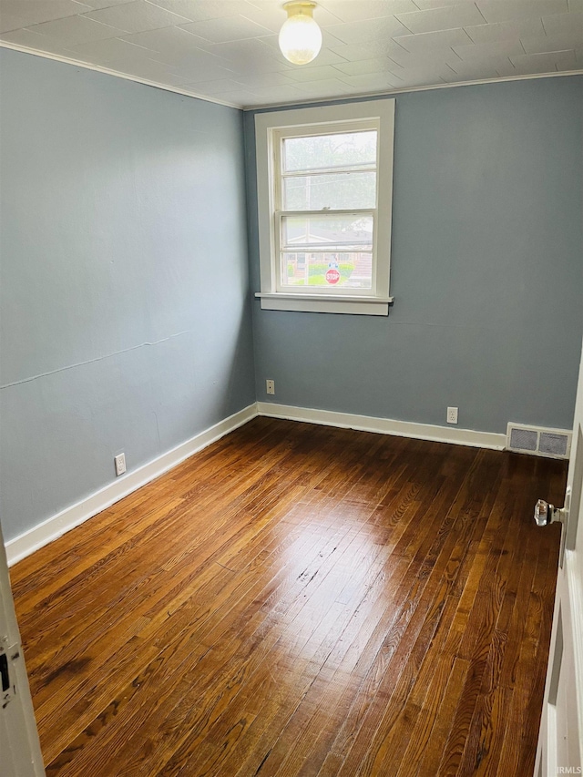 spare room featuring dark wood finished floors, baseboards, and visible vents