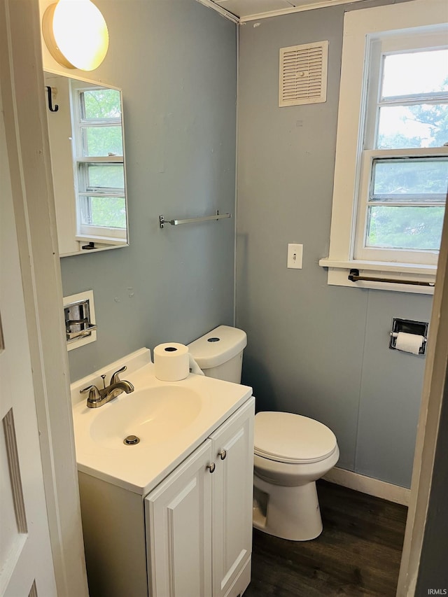 half bathroom featuring visible vents, plenty of natural light, toilet, and vanity