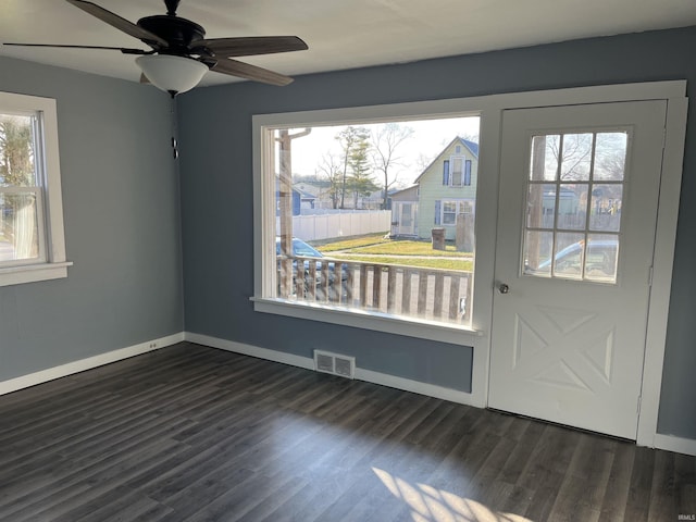 interior space with dark wood-type flooring, baseboards, visible vents, and ceiling fan