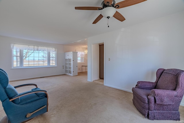 living area with baseboards, light carpet, visible vents, and ceiling fan