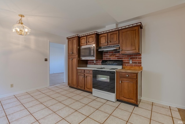 kitchen featuring light countertops, electric stove, under cabinet range hood, stainless steel microwave, and backsplash