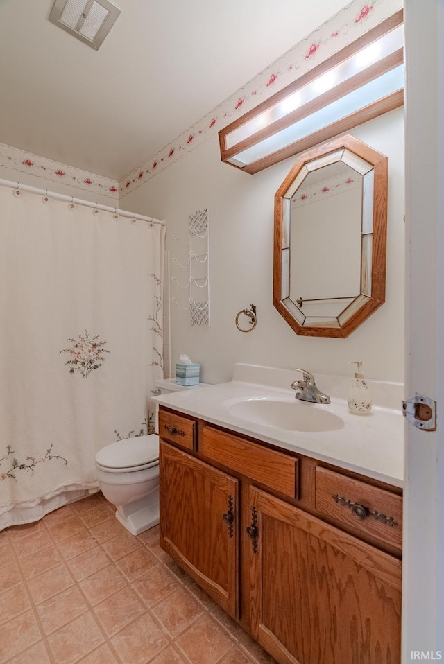 bathroom with toilet, vanity, and a shower with shower curtain