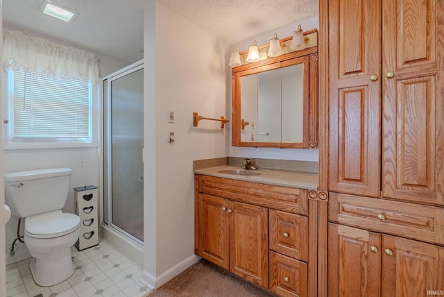 bathroom with vanity, toilet, a stall shower, and a textured ceiling