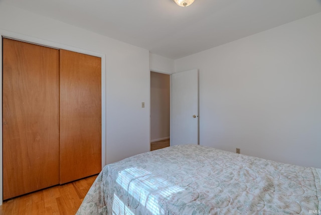 bedroom with light wood-style floors and a closet