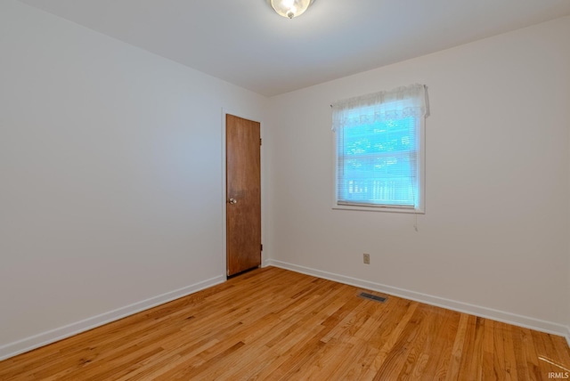 spare room featuring visible vents, light wood-style flooring, and baseboards