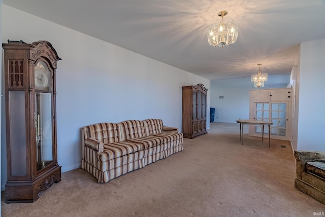 carpeted living area featuring a chandelier