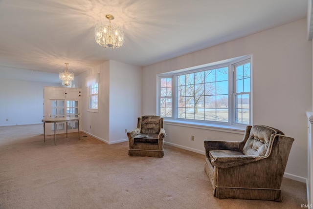 sitting room with a notable chandelier, baseboards, and carpet