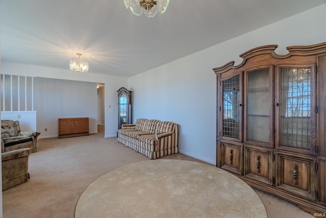 sitting room featuring a notable chandelier, light colored carpet, and baseboards