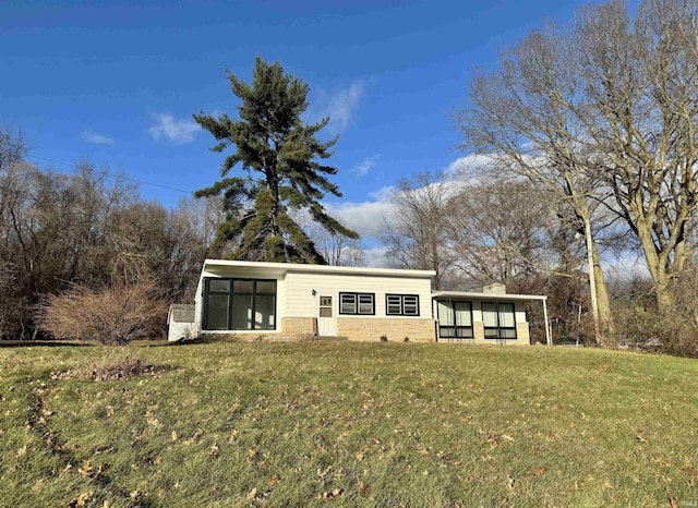 view of front facade with a front lawn and a sunroom