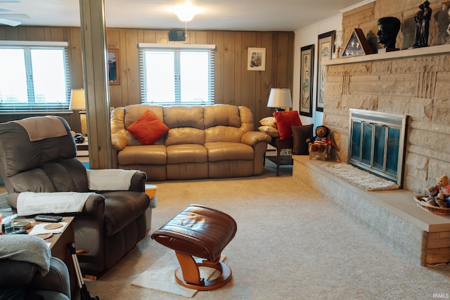 carpeted living area featuring wooden walls and a fireplace