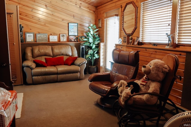 carpeted living area with wood walls