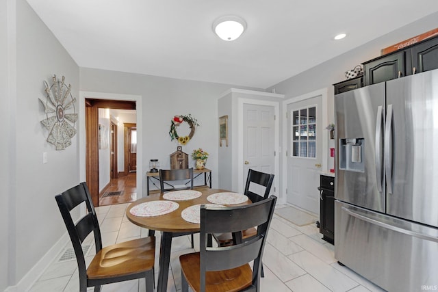 dining room featuring light tile patterned floors, visible vents, and baseboards