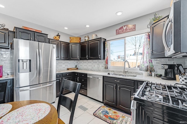 kitchen with backsplash, appliances with stainless steel finishes, and a sink