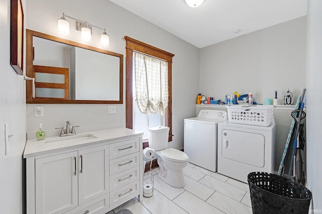 bathroom featuring vanity, toilet, and washing machine and dryer