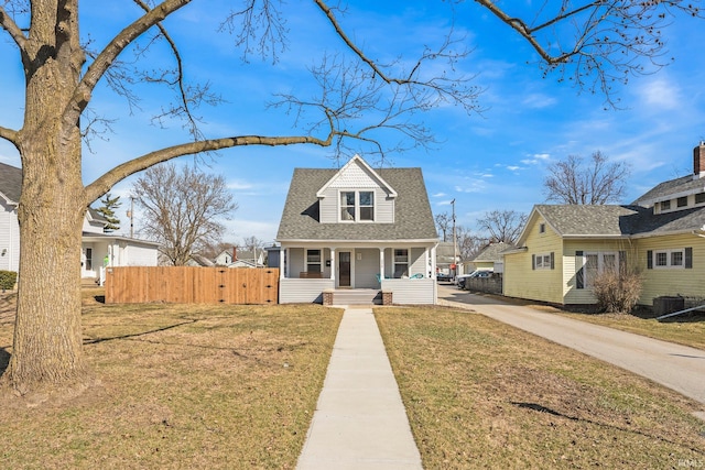 view of front of property featuring a front yard, a gate, fence, a porch, and concrete driveway