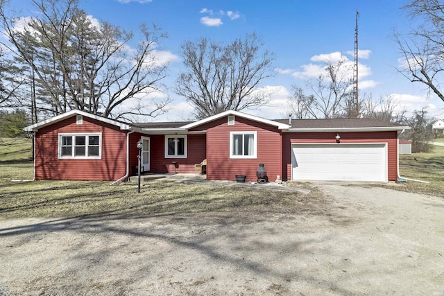 ranch-style house featuring driveway, an attached garage, and a front lawn