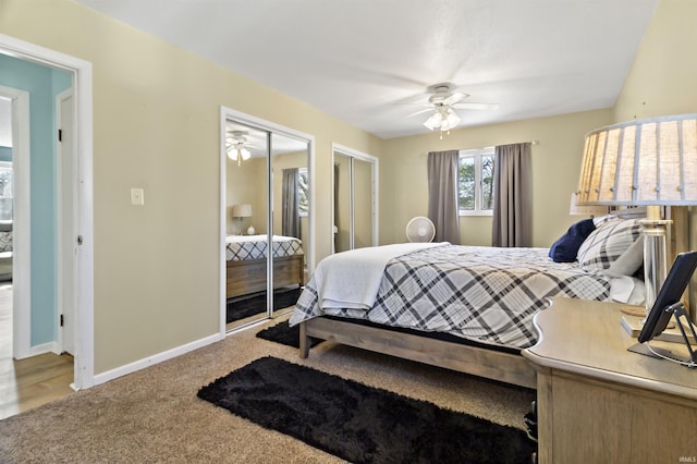 carpeted bedroom featuring baseboards, multiple closets, and ceiling fan