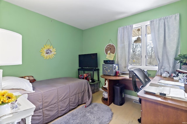 bedroom with baseboards and wood finished floors