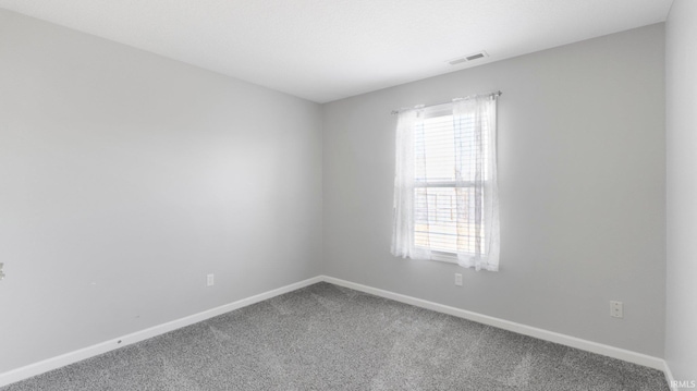 empty room featuring visible vents, a healthy amount of sunlight, baseboards, and carpet