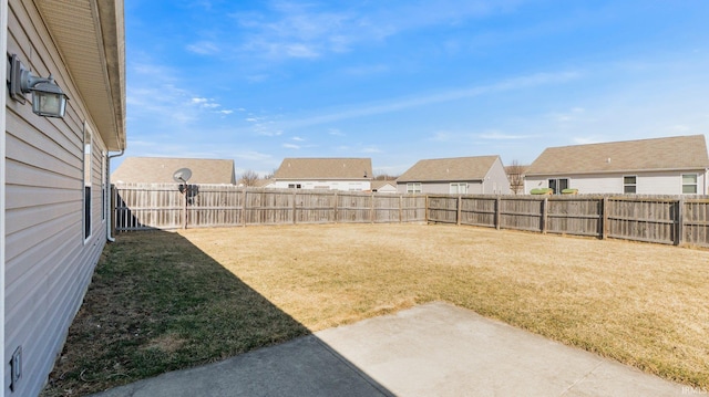 view of yard featuring a patio area, a residential view, and a fenced backyard