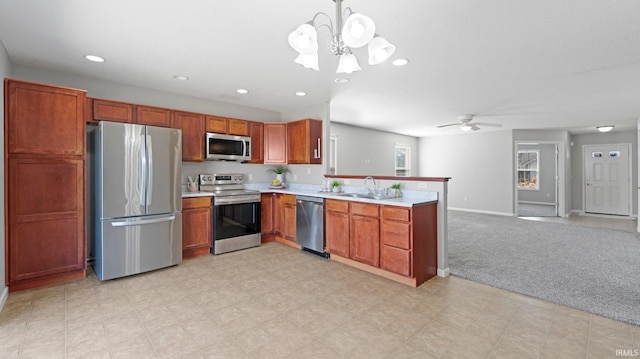 kitchen featuring light countertops, light carpet, a peninsula, stainless steel appliances, and a sink