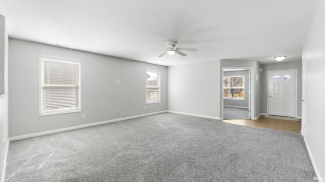 unfurnished room with baseboards, ceiling fan, and carpet floors